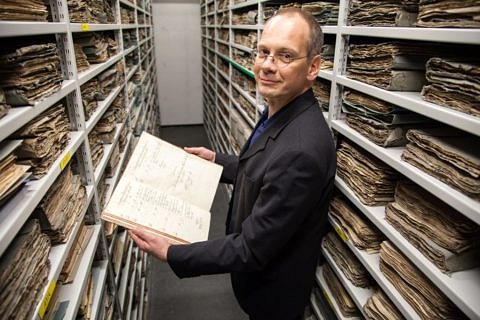 The University's archivist Dr. Clemens Wachter going through FAU's history. (Image: Georg Pöhlein)