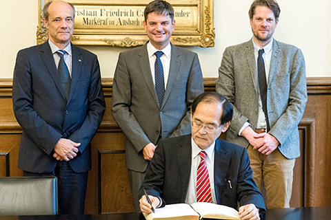 Consul General Hidenao Yanagi (front) signing FAU's Golden Book, accompanied by FAU Vice President Prof. Dr. Günter Leugering, FAU President Prof. Dr. Joachim Hornegger and Prof. Dr. Fabian Schäfer from the Chair of Japanese studies. (Image: Franziska Sponsel)