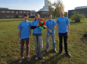 The FAU team (left to right): Tobias Netter, Raphaela Prach, Benjamin Mockenhaupt and Lukas Dresel with ESA mascot Paxi in front of the Bremen drop tower. (Image: private)