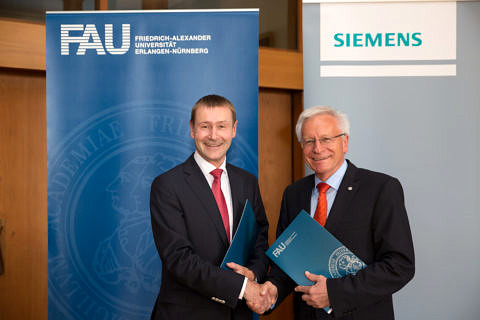 Prof. Dr. Karl-Dieter Grüske, President of FAU and Klaus Helmrich, Chief Technology Officer and Chief Human Resources Officer of Siemens AG (Image: FAU/Erich Malter)