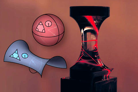 A laser beam in an experiment propagates along the two-dimensional surface of a glass object shaped like an hourglass, curling once around the middle of the object. This is an example of an object with negative surface curvature (like a saddle, for example), in contrast to an object with positive surface curvature, such as a sphere. (Image: Vincent Schultheiß)