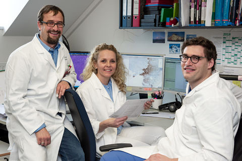 Dr. Markus Eckstein (right, pathology) and PD Dr. Benjamin Frey (translational research) and Sandra Rutzner (secretary's office for studies) from the Department of Radiation Oncology in Erlangen complete documentation for the first CheckRad-CD8 patient. (Photo: Michael Rabenstein/Universitätsklinikum Erlangen)