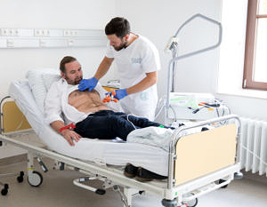 Two men in a hospital room.