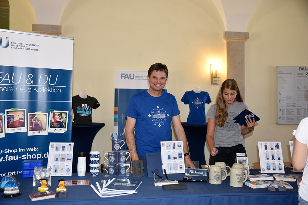 To mark the sales launch on 2 July in the Erlangen Schloss, FAU President Joachim Hornegger himself took a turn behind the sales counter – in an FAU t-shirt, of course. (Image: FAU/Rebecca Kleine Möllhoff)