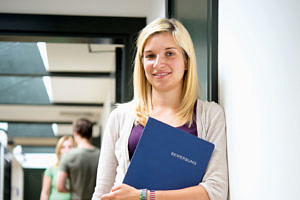 Student with folder under her arm.