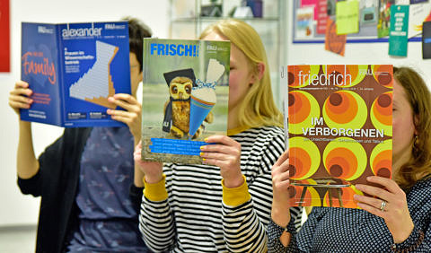 Three women read a magazine.