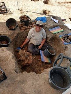 A woman sitting in a hole in the ground.