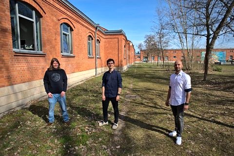 Three people in front of a building.