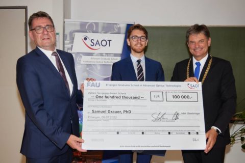 Prof. Stefan Will (left) and FAU President Joachim Hornegger (right) present the SAOT Young Researcher Award 2022 to Samuel Grauer, PhD. (Bild: FAU/Erich Malter)