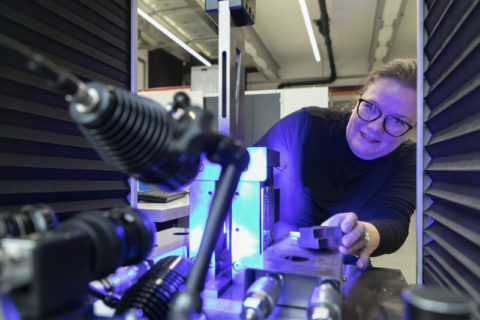 Photo of a woman with glasses working on a machine