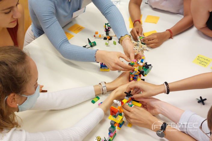 Women at a Femtec event building something with lego.