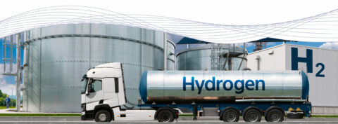 Ein Lastwagen mit einem Wasserstoff-Anhänger vor einer Fabrik.