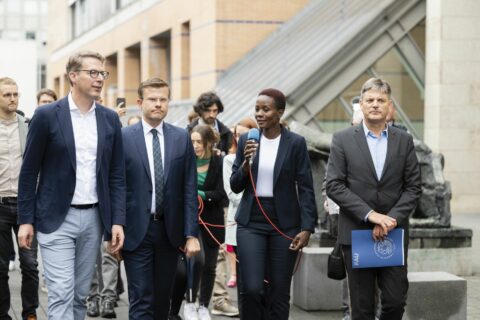 FAU doctoral student Aneth Lwakatare-Thumm explains science minister Markus Blume, Nuremberg's Lord Mayor Marcus König and FAU President Joachim Hornegger (from left) explain Article 25 "Right to an Adequate Standard of Living" of human rights. (Image: FAU/Uwe Niklas)