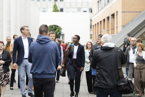 Aneth Lwakatare-Thumm, doctoral candidate at FAU, explains the column of Art. 25 „Right to standard of adequate living” to Minister of Science Markus Blume, Nuremberg mayor Marcus König and FAU president Joachim Hornegger (f.l.). (Picture: FAU/Uwe Niklas)