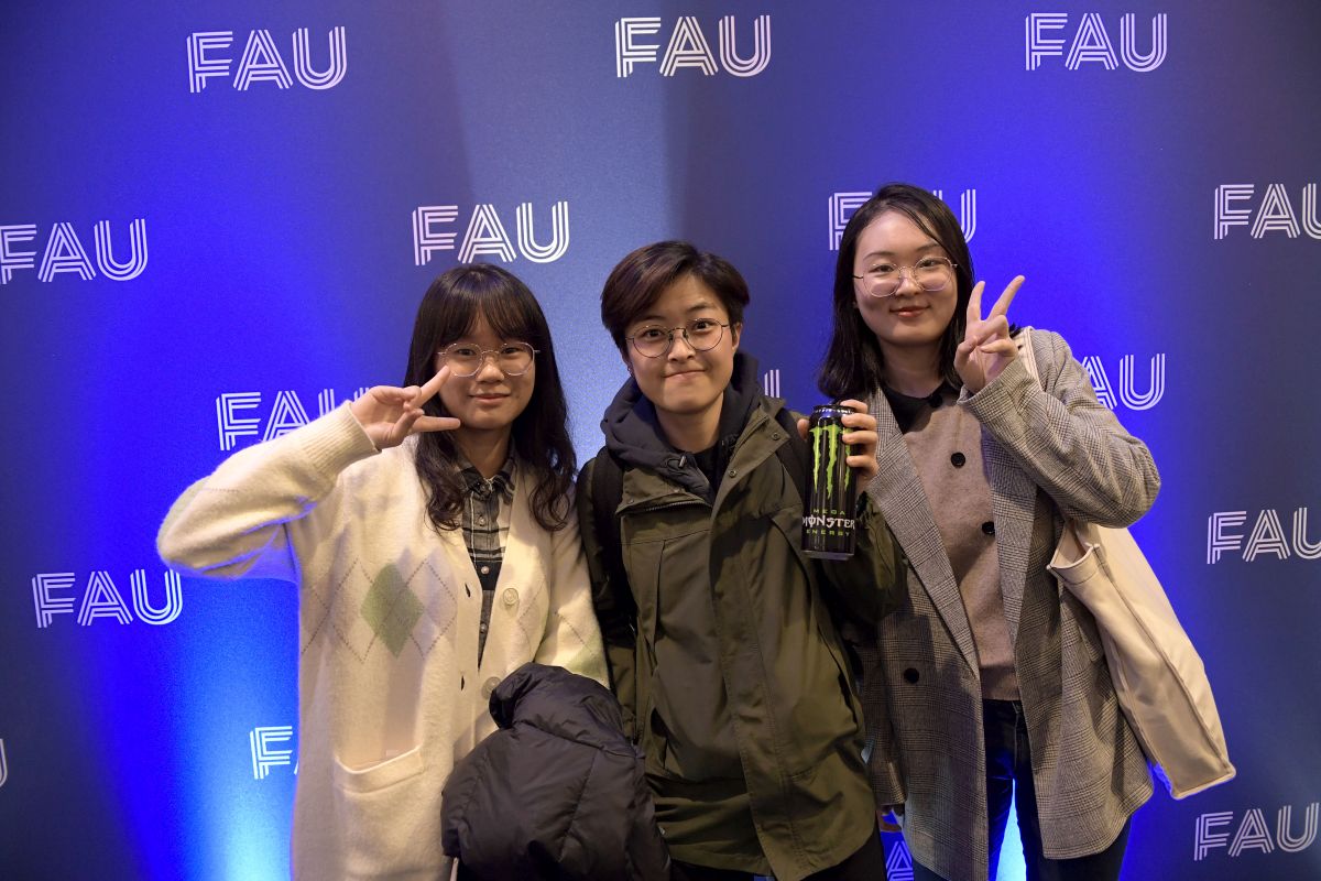 Photo of three students showing the peace sign with their fingers