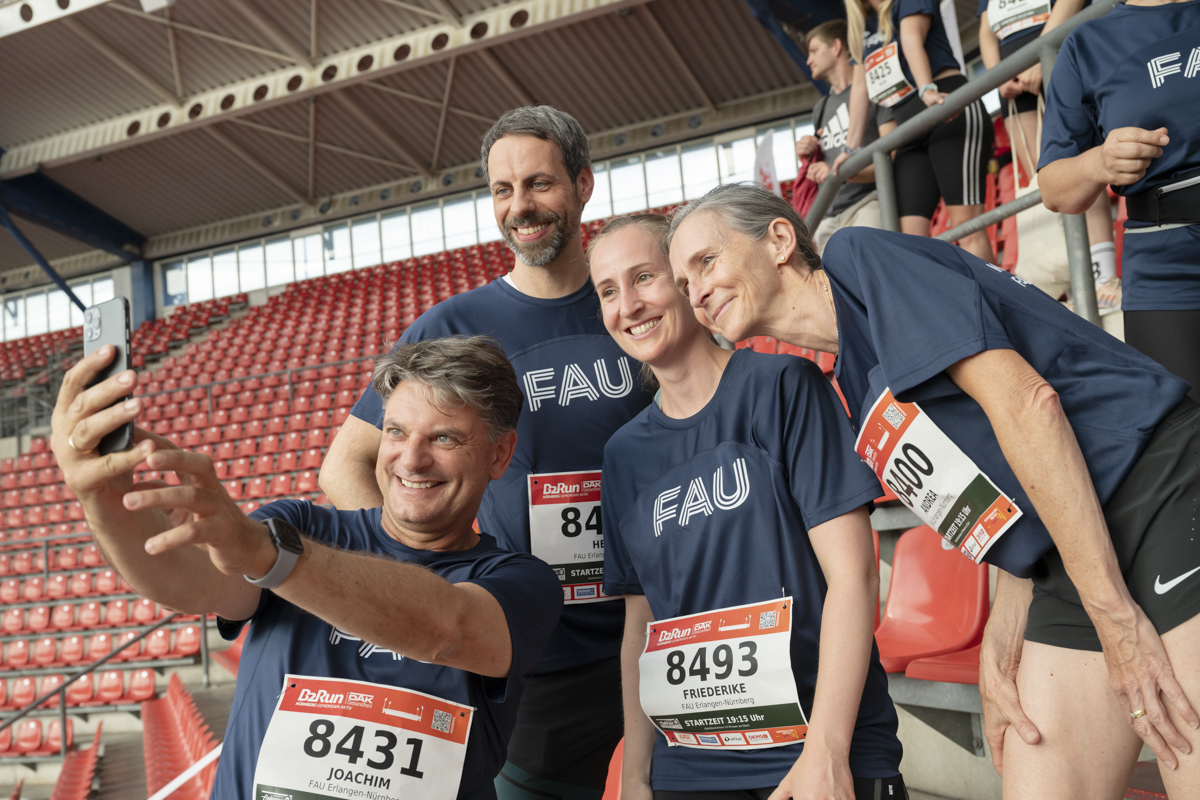 FAU president Prof. Dr. Joachim Hornegger taking a selfie with some of the FAU runners.