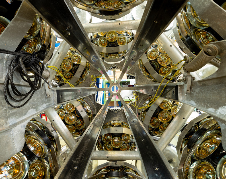 An assembled DOM. Lower and upper half spheres coupled together to form a complete DOM with 31 light-sensitive PMTs. A titanium collar is placed around the glass sphere allowing to attach the DOM to the ropes which hold the DU vertically.