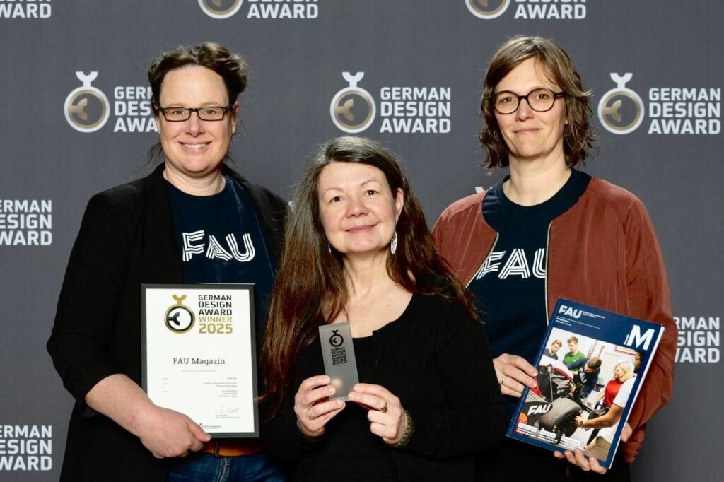 3 women smile into the camera with the design in their hands.