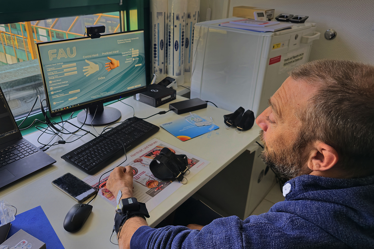 Elderly man practicing with his prosthesis at his work table.