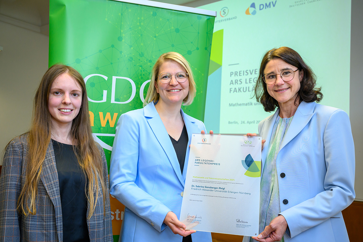The 3 women, left student with long hair, center, Gensberger with blond half-long hair and , Henicke older with dark hair, with the award certificate in their hands.