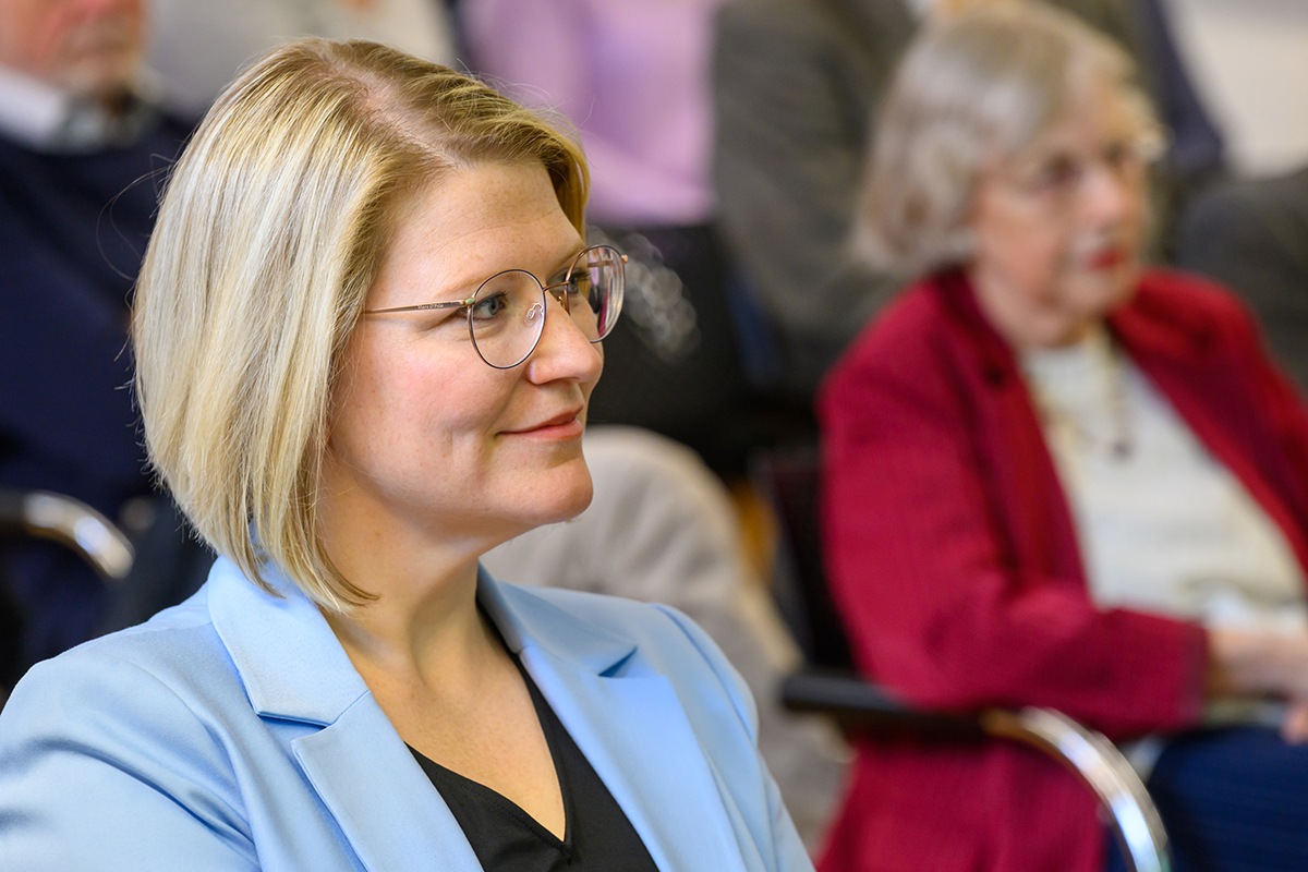 Portrait of Gensberger, a middle-aged blonde woman with glasses and a pageboy cut.