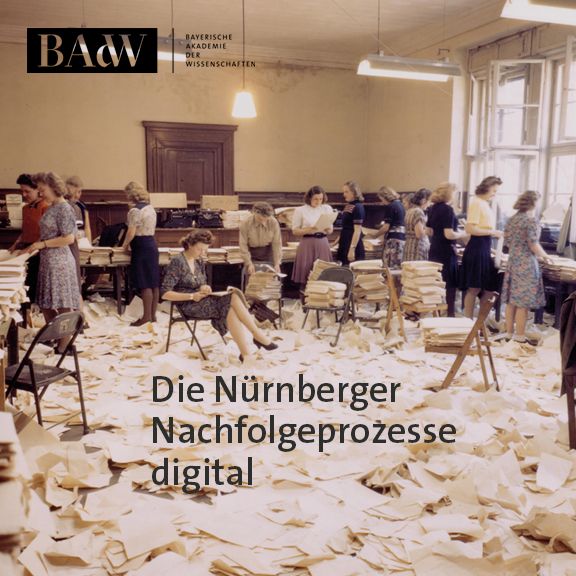 Frauen sitzen in Bergen von Papier, der ganze Boden ist mit Papier bedeckt, auf Stühlen sind Papierstapel abgelegt