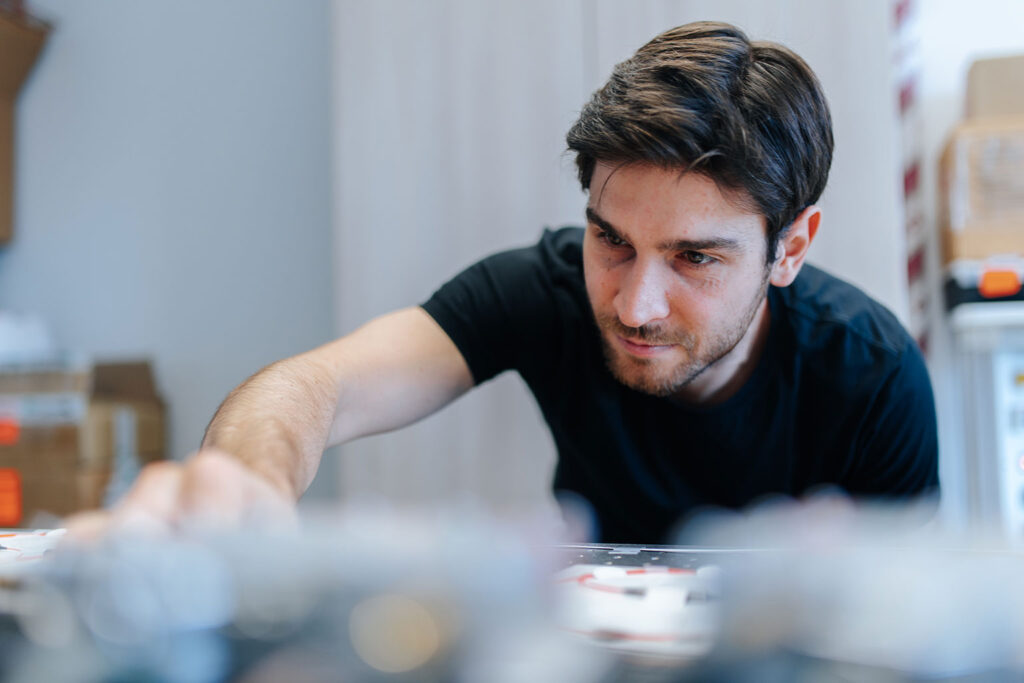 Ein junger Forschender nimmt gerade eine Einstellung vor, der Vordergrund ist unscharf, daher sieht man nicht genau woran.