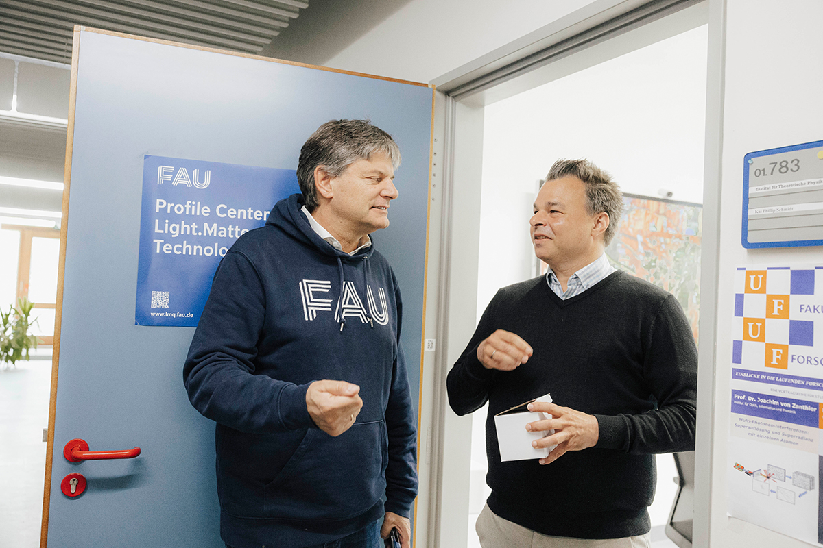 Prof. Dr. Schmidt and President Hornegger are standing together in a doorway chatting.