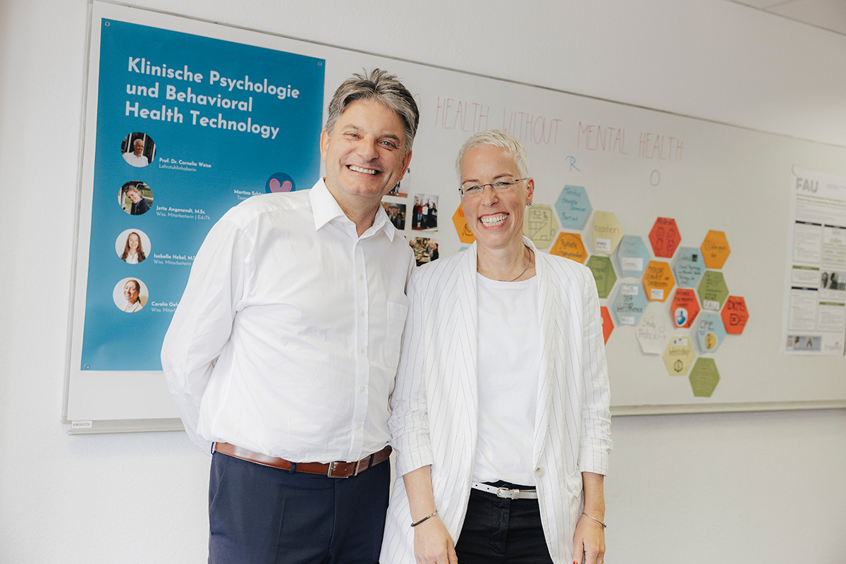 Prof. Weise und Präsident Hornegger stehen nebeneinander und lächeln. Sie schauen den Betrachter an. Prof. Weise and President Hornegger are standing next to each other and smile. Both face the camera.