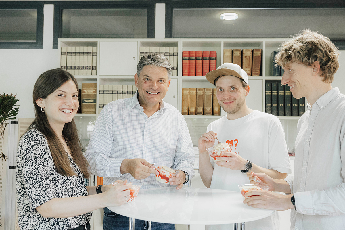 FAU President Hornegger, Prof. Dr. Reif and Prof. Reif’s team are standing around a table eating ice cream.