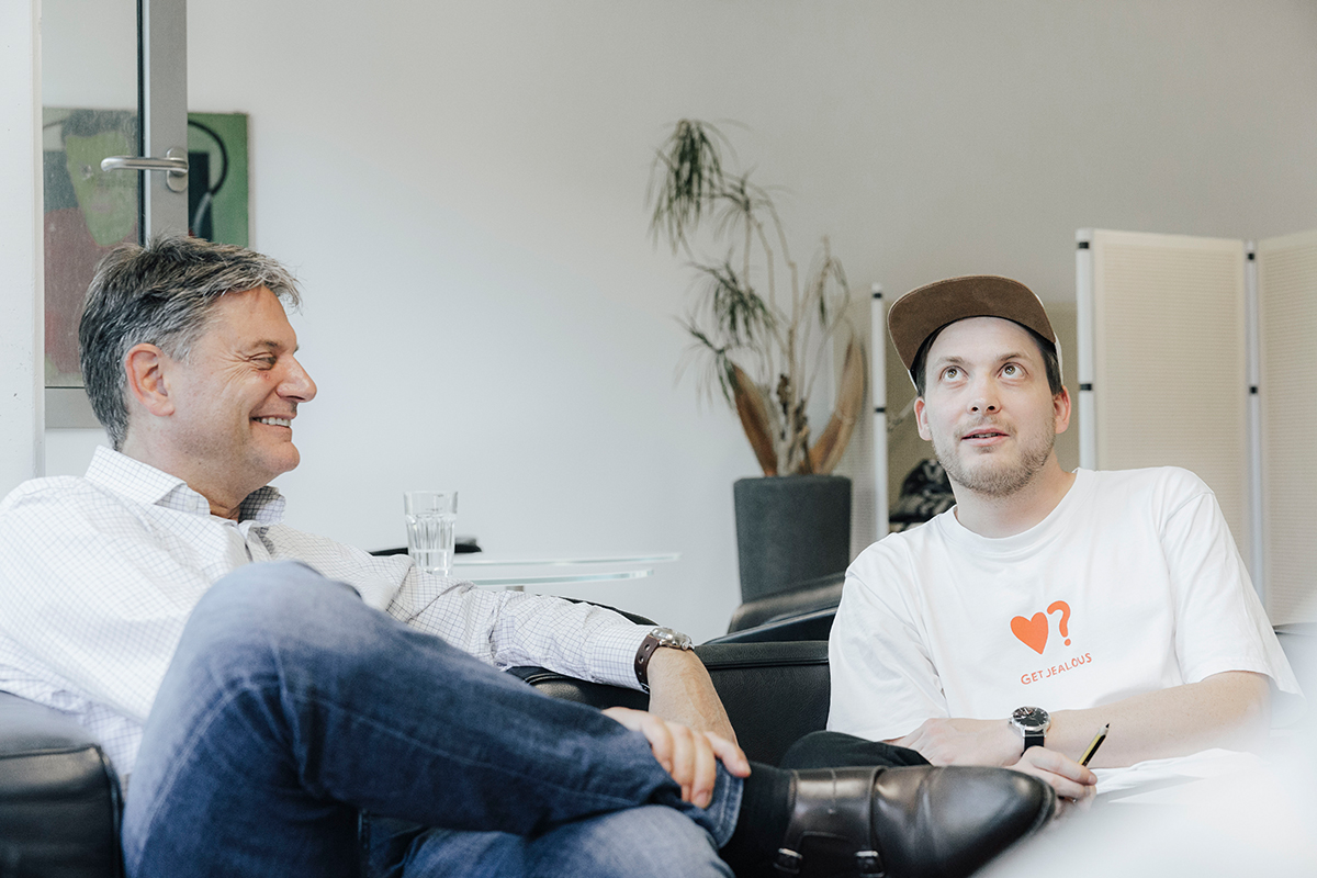 Joachim Hornegger and Simon Reif are sitting on a couch, speaking.