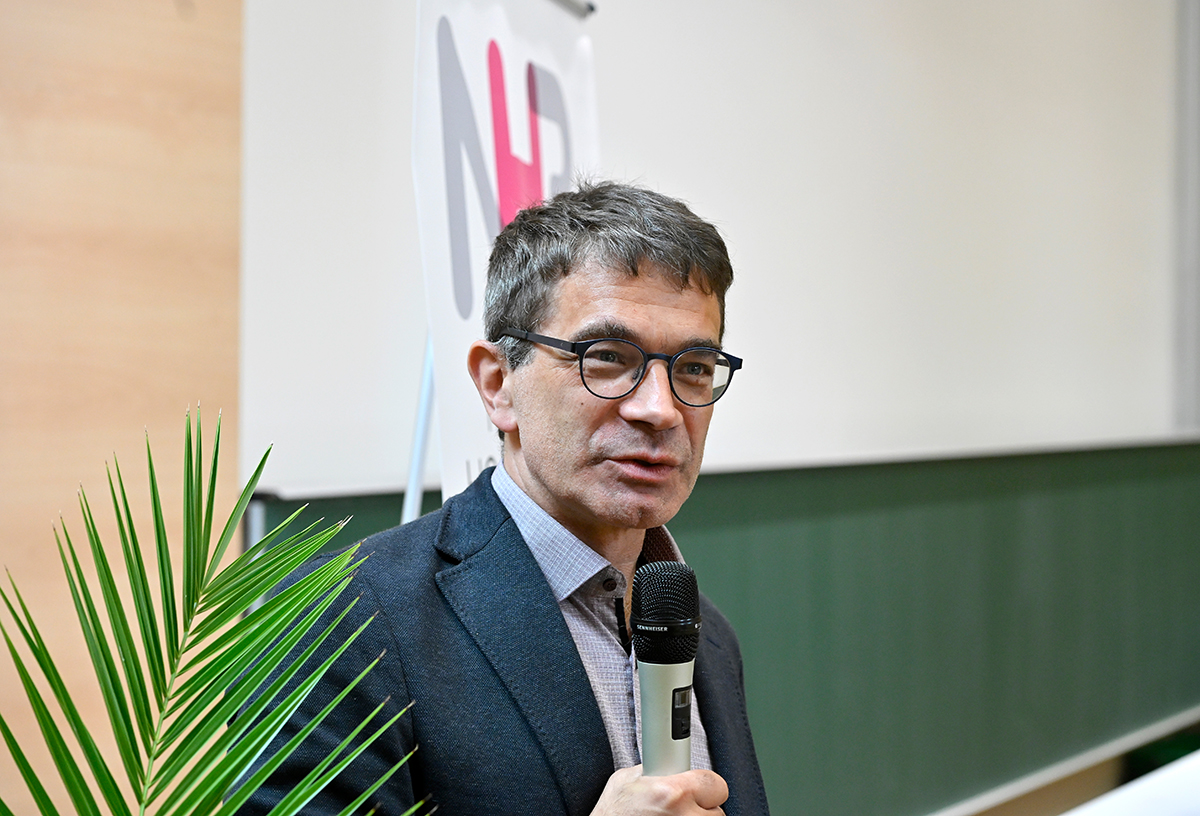 Prof. Wellein, an older man with glasses, microphone in hand