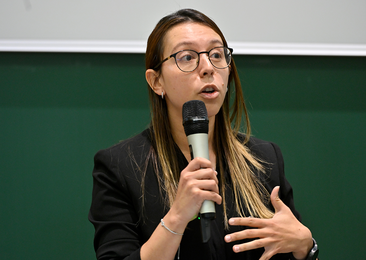 Ms. Perez Torro, a young scientist with glasses, gives a speech