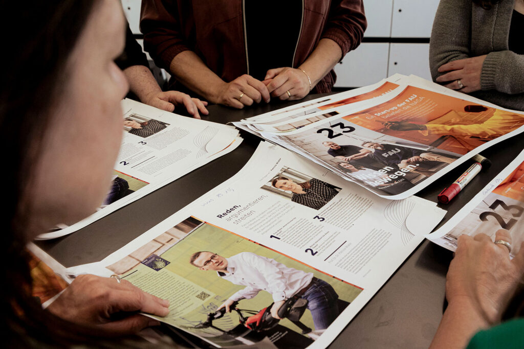 Mehrere Menschen sitzen gemeinsam an einem Tisch an einem Magazin.