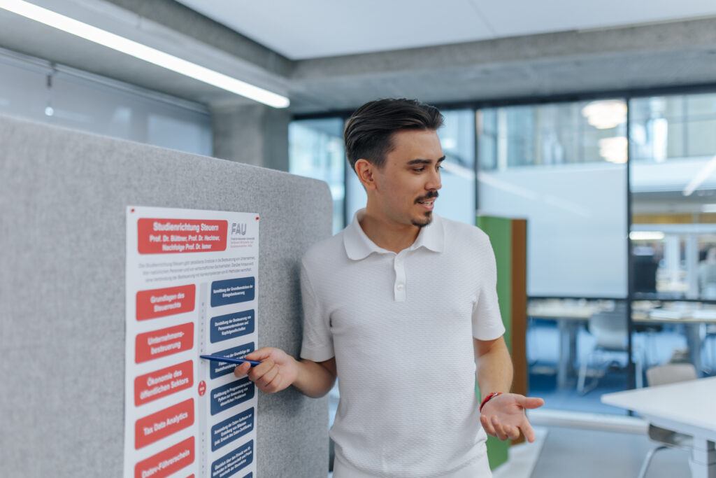 Mann erklärt etwas an Pinnwand