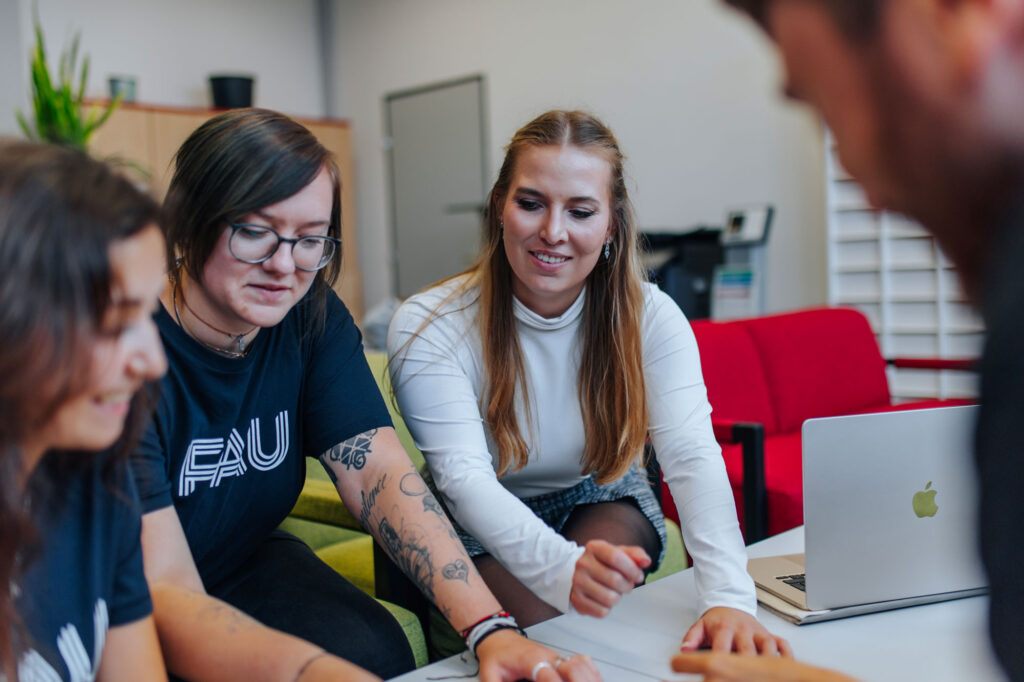 Studierende schauen zusammen auf ein Blatt Papier