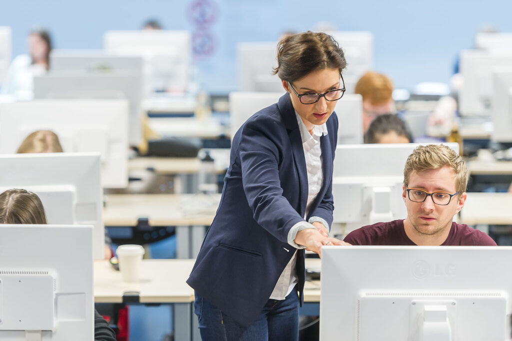 Eine Frau zeigt einem Mann etwas an einem Bildschirm.