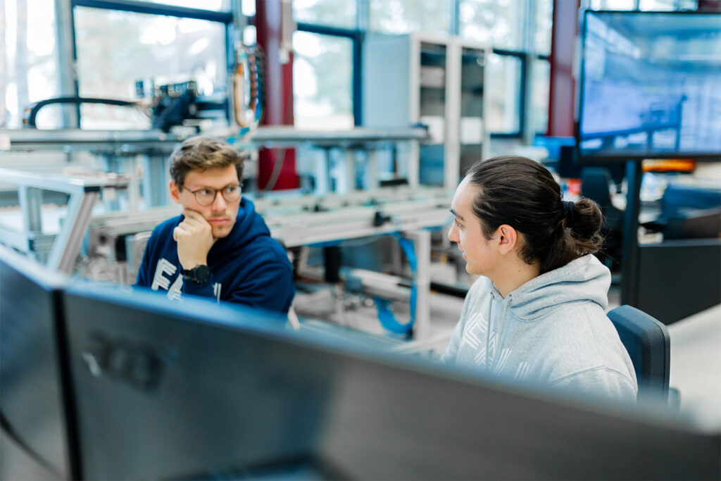 Zwei Forschende besprechen sich an ihrem Schreibtisch.