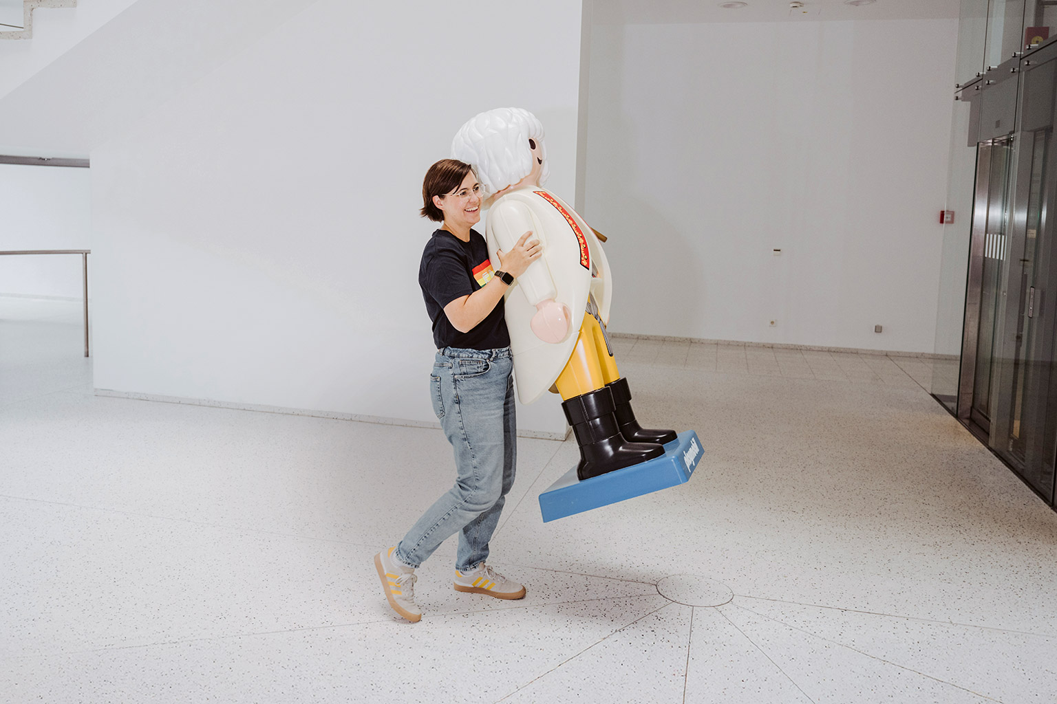 Laura Kneppe is carrying a large Playmobil figure.