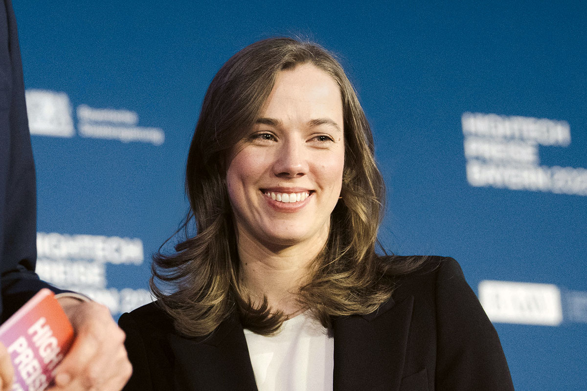 Johanna Geis stands on stage and smiles at the camera.