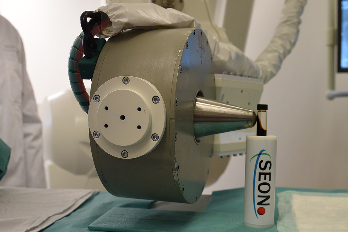 Der große Magnet zieht die Eisenpartikel, die in einem Glasbehälter sind, an.