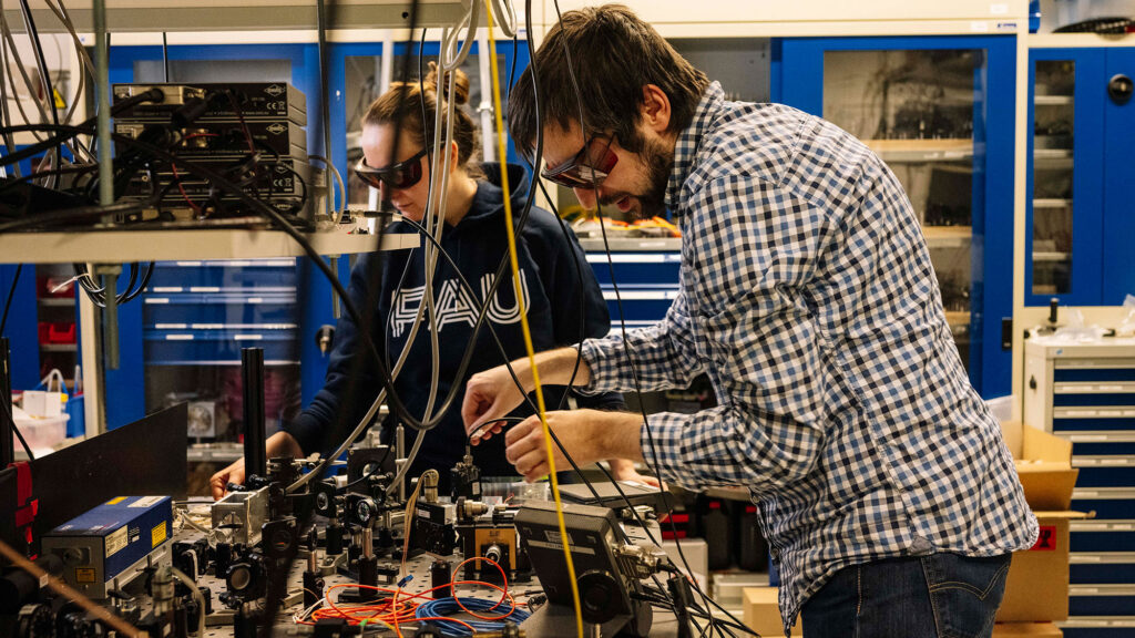 Two scientists working on a machine.