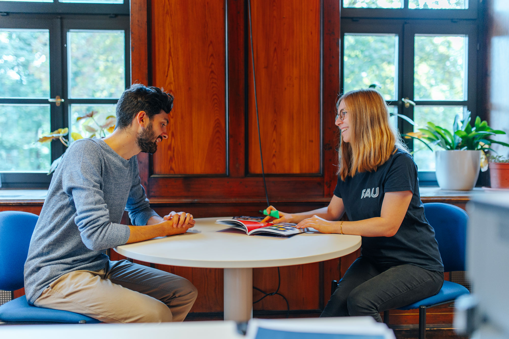 A student and a counselor sitting at a round table.
