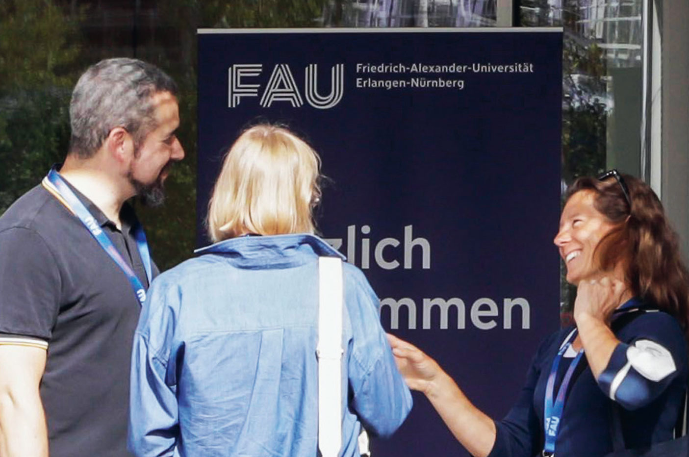 People talking to each other in front of a FAU building.