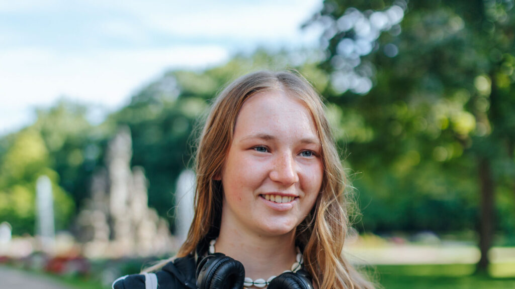 A student with headphones around her neck.