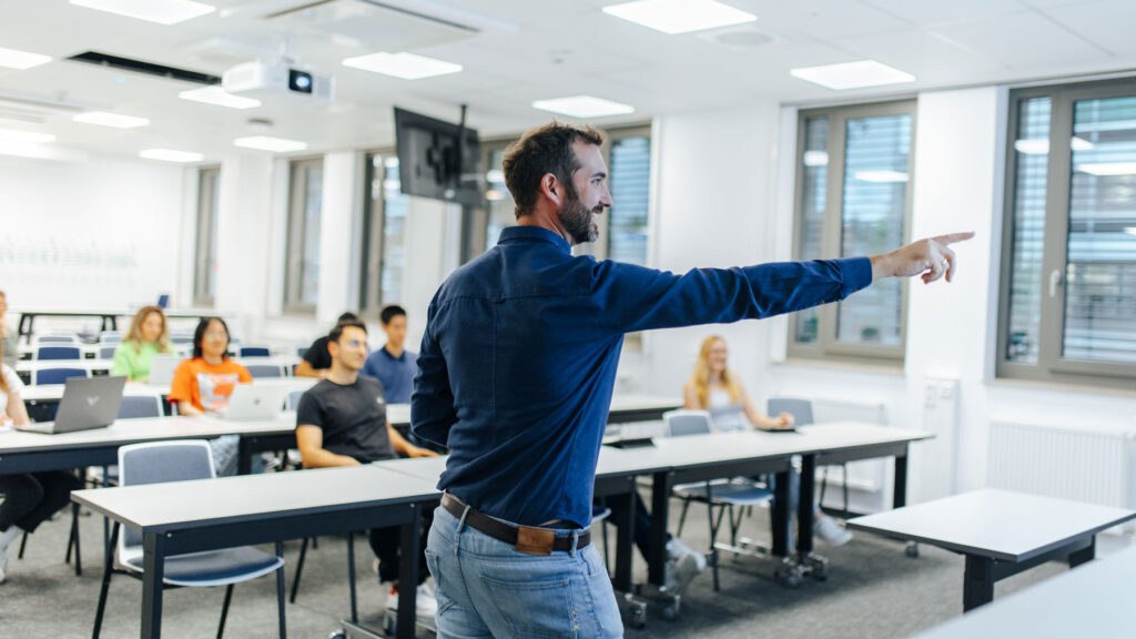 A teacher is showing his students something on a screen.