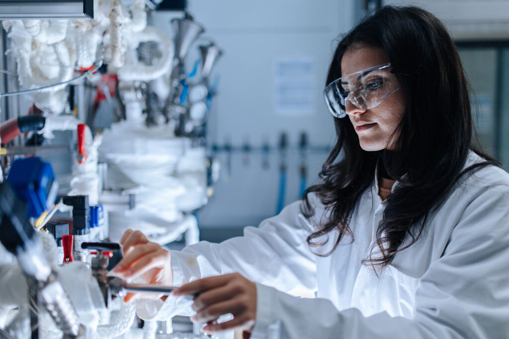 A female scientist in a laboratory in front of a complex machine.