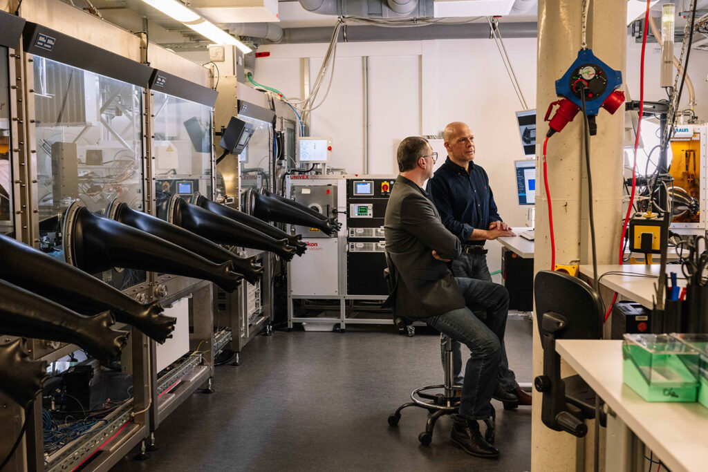 Two scientists talking to each other in a laboratory.