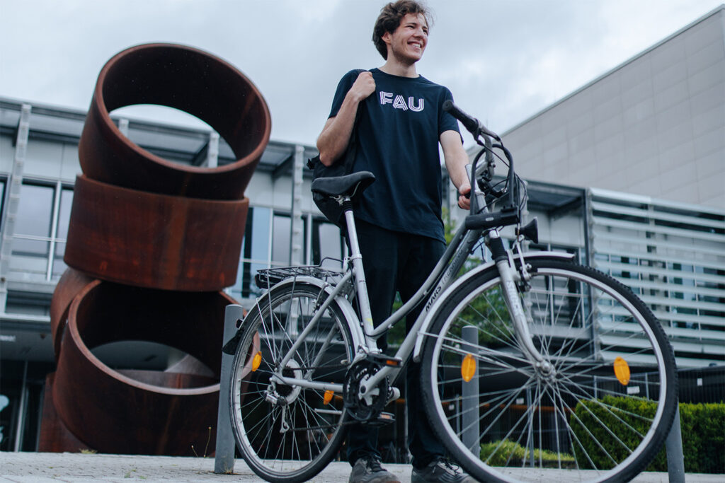 Student mit FAU-Shirt und Fahrrad