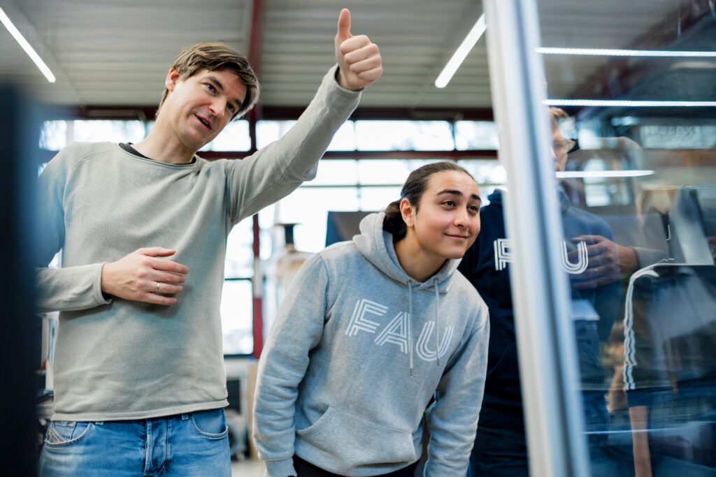 The male researcher gives a thumbs-up, while the female researcher looks intently.